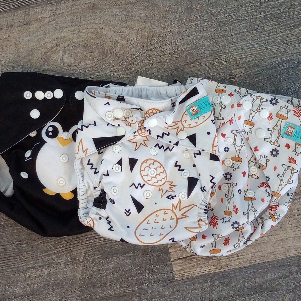 Three Cloth diaper covers - pineapples, penguin, and giraffe